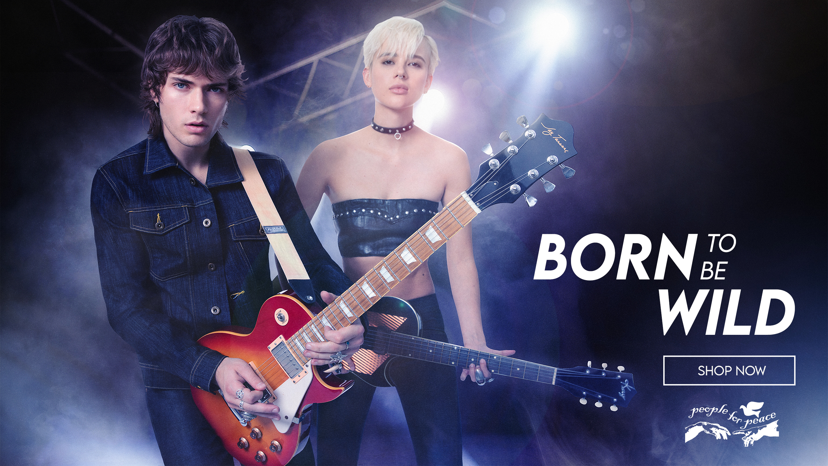 
A muscular man with short hair and tattoos stands in profile, leaning on a rustic wooden fence. He is wearing a black, sleeveless top with a white graphic print, black leather pants, and red motorcycle boots. He holds a red and black helmet in his left hand. The background is a dirt road bordered by trees, with sunlight filtering through the leaves. The image has a dark, vertical overlay on the left side with the text 