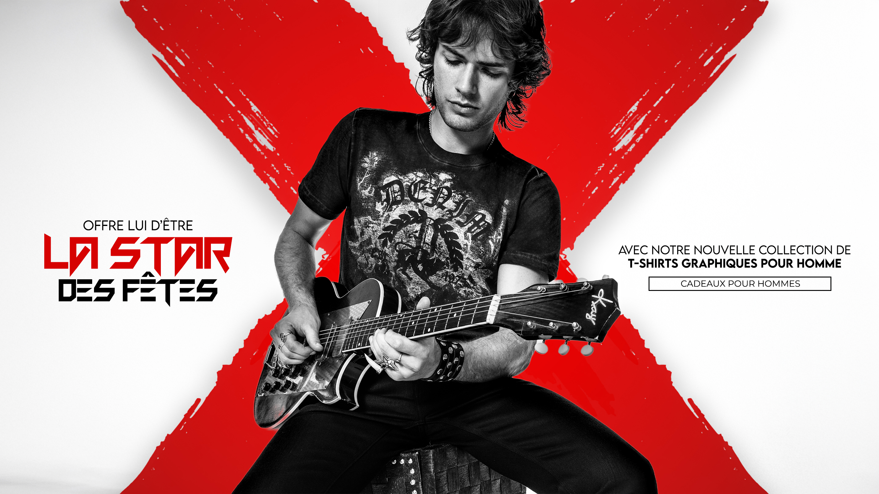 
A muscular man with short hair and tattoos stands in profile, leaning on a rustic wooden fence. He is wearing a black, sleeveless top with a white graphic print, black leather pants, and red motorcycle boots. He holds a red and black helmet in his left hand. The background is a dirt road bordered by trees, with sunlight filtering through the leaves. The image has a dark, vertical overlay on the left side with the text 'SHOW THEM GUNS THE NEW MUSCLE TEE' and 'SHOP THE 9703NS.'